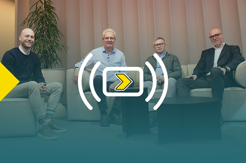 ชายสี่คนนั่งบนโซฟาหันหน้าเข้าหากล้อง ภาพมีการซ้อนทับแบบไล่ระดับสีพร้อมโลโก้งานสัมมนาออนไลน์ของ Axelent “Axelent Goes Live”