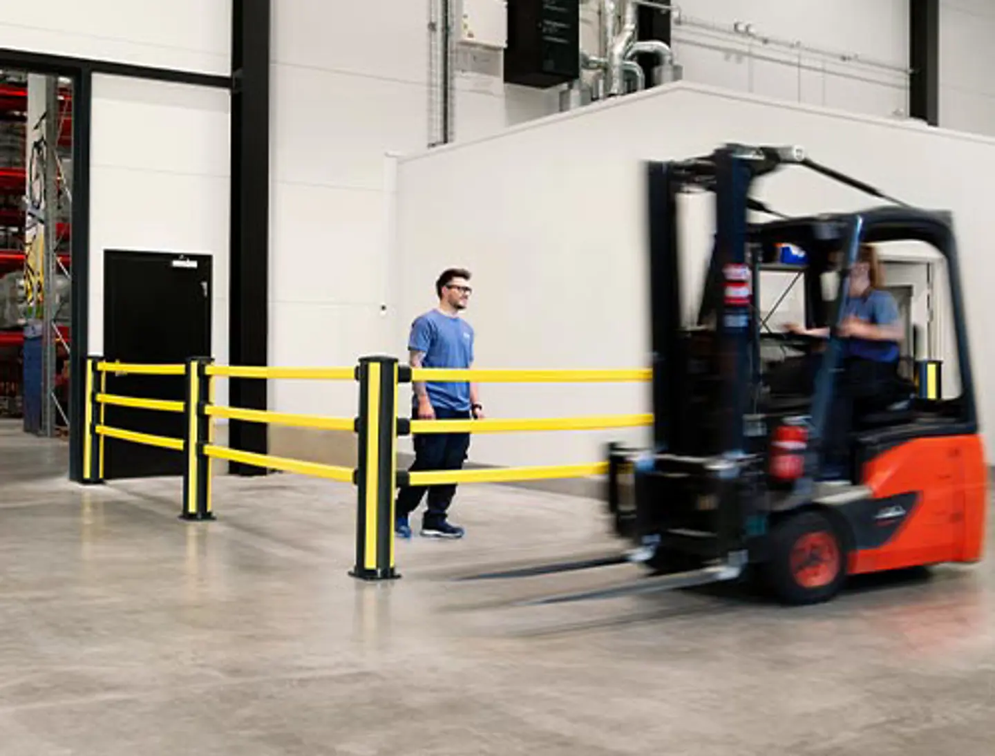 Pedestrian safety barrier installed in a warehouse environment to prevent collisions between forklifts and foot traffic.